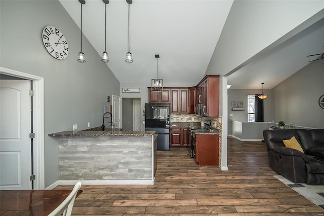 kitchen with open floor plan, dark wood-style flooring, pendant lighting, and refrigerator