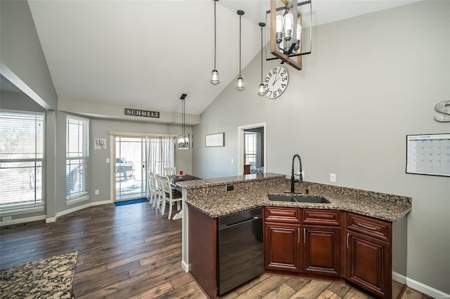 kitchen with dishwasher, wood finished floors, a sink, and light stone counters