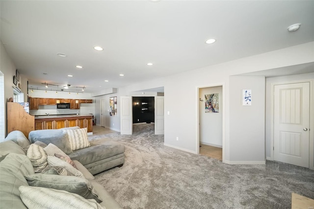 living area with rail lighting, recessed lighting, baseboards, and light colored carpet