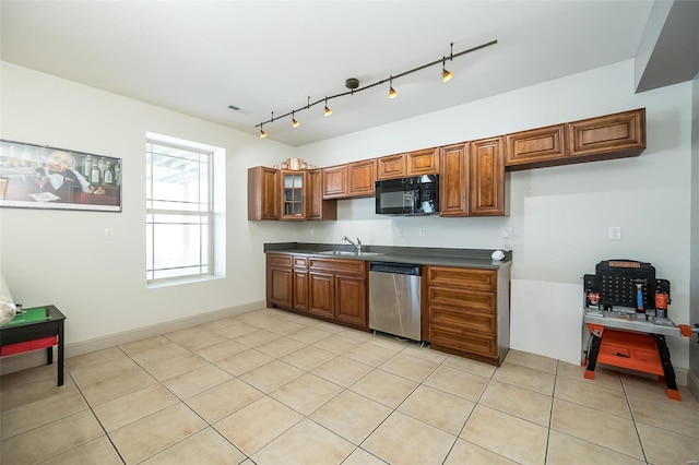 kitchen featuring dishwasher, dark countertops, glass insert cabinets, brown cabinets, and black microwave