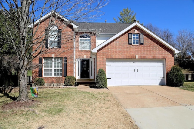 traditional home with fence, driveway, an attached garage, a front lawn, and brick siding