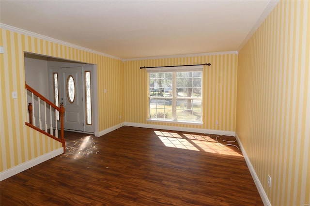 entryway with wood finished floors, baseboards, wallpapered walls, ornamental molding, and stairs