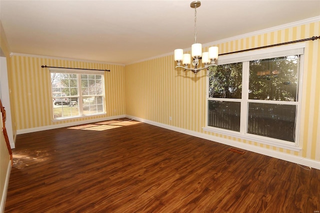 unfurnished room featuring baseboards, wood finished floors, and crown molding