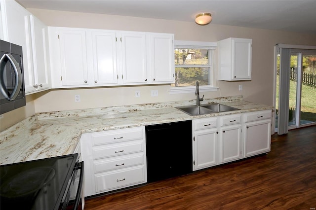 kitchen with light stone counters, a sink, black appliances, dark wood-type flooring, and white cabinetry