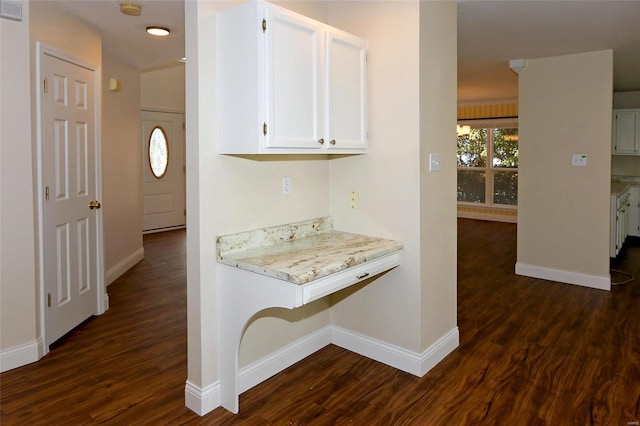 corridor with dark wood finished floors, visible vents, and baseboards