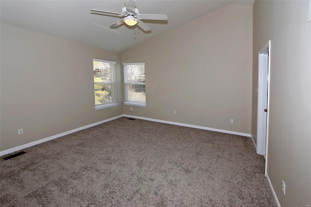 empty room featuring visible vents, lofted ceiling, carpet, and baseboards