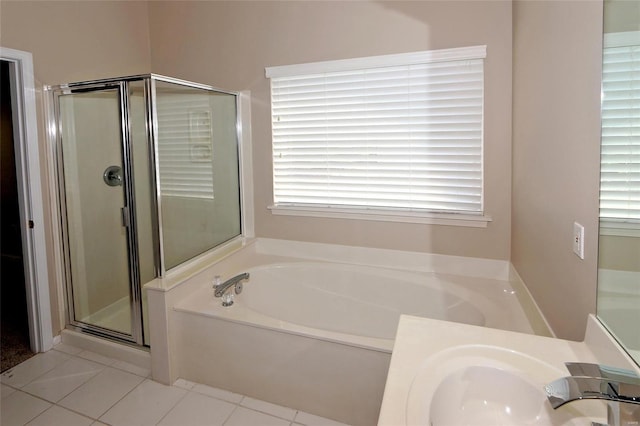 full bath with tile patterned floors, a bath, a shower stall, and a sink