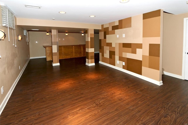 interior space featuring wallpapered walls, baseboards, and wood finished floors