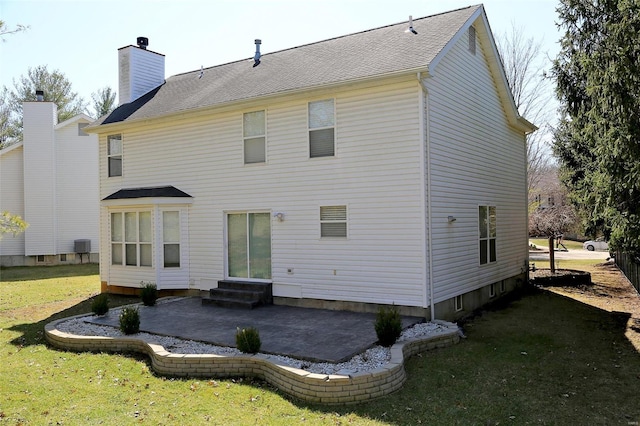 rear view of house featuring a patio area, a yard, a chimney, and entry steps