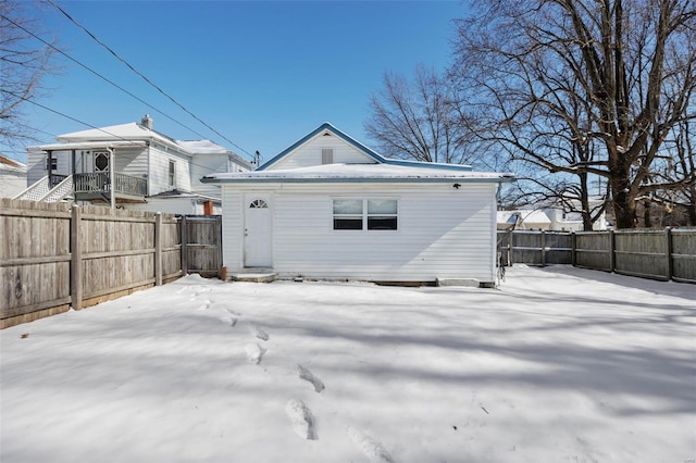 snow covered property featuring a fenced backyard