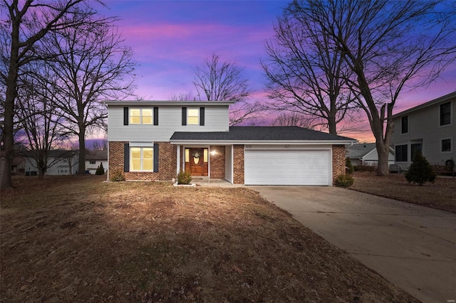 traditional-style house featuring a garage, driveway, and brick siding