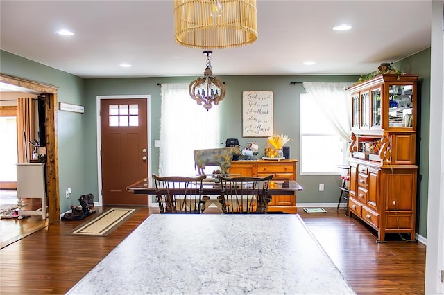 dining area featuring dark hardwood / wood-style flooring, plenty of natural light, and a notable chandelier