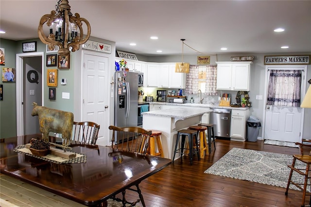 dining area with a chandelier, sink, and dark hardwood / wood-style flooring