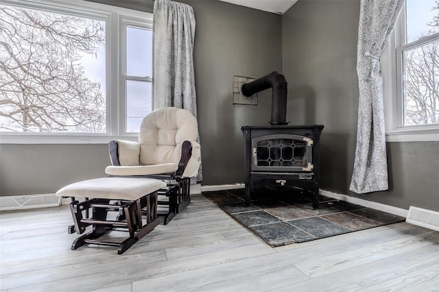 living area with wood-type flooring and a wood stove