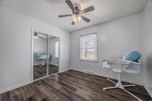 unfurnished bedroom with dark wood-type flooring, ceiling fan, and a closet