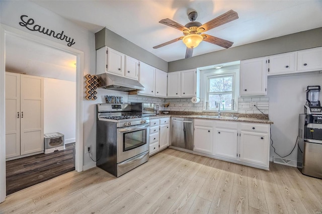 kitchen with white cabinetry, stainless steel appliances, sink, and decorative backsplash