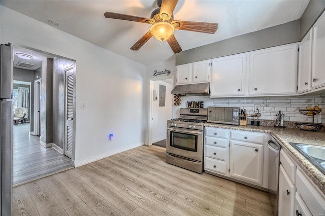 kitchen with appliances with stainless steel finishes, backsplash, white cabinets, and light hardwood / wood-style floors