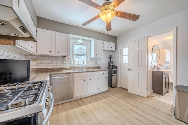 kitchen featuring white cabinetry, sink, light hardwood / wood-style floors, and appliances with stainless steel finishes