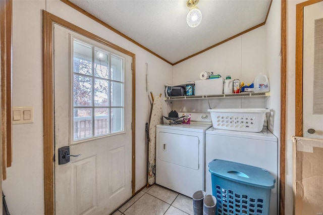 clothes washing area with crown molding, washing machine and clothes dryer, a textured ceiling, and light tile patterned floors