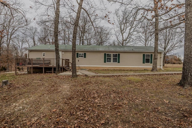 rear view of property featuring a wooden deck