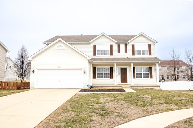 traditional-style house featuring driveway, a front yard, a garage, and fence