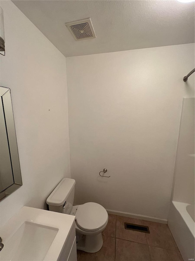 bathroom featuring vanity, toilet, tile patterned flooring, and a textured ceiling