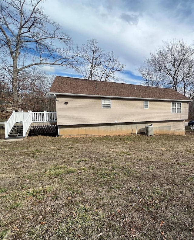 view of property exterior featuring a wooden deck, central AC unit, and a lawn