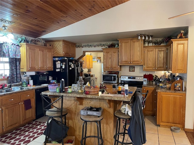 kitchen with a kitchen island, lofted ceiling, sink, a kitchen breakfast bar, and black appliances