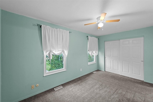 unfurnished bedroom with ceiling fan, a closet, carpet, and visible vents