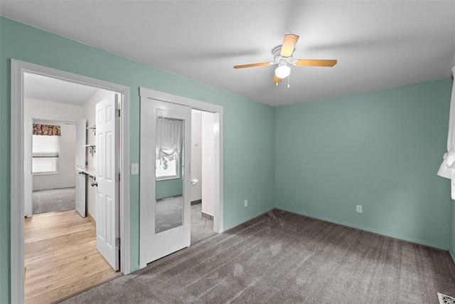 unfurnished bedroom featuring multiple windows, a ceiling fan, and carpet flooring