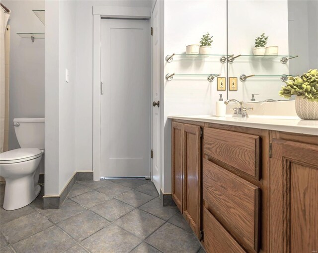 full bath featuring tile patterned flooring, toilet, vanity, baseboards, and a closet