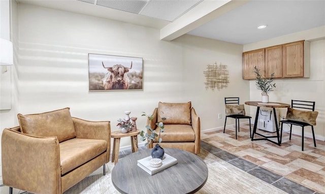 sitting room featuring stone finish flooring, baseboards, and recessed lighting