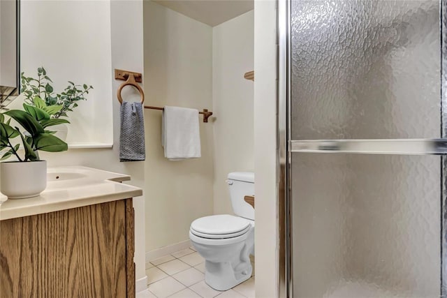 bathroom featuring toilet, vanity, baseboards, tile patterned floors, and a stall shower