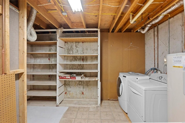 washroom with laundry area, water heater, and separate washer and dryer