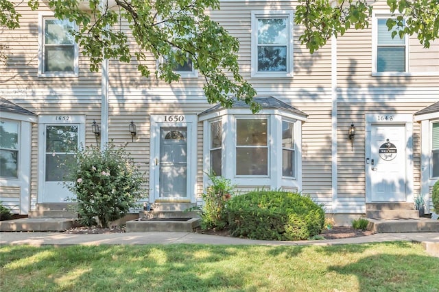 view of exterior entry with a lawn