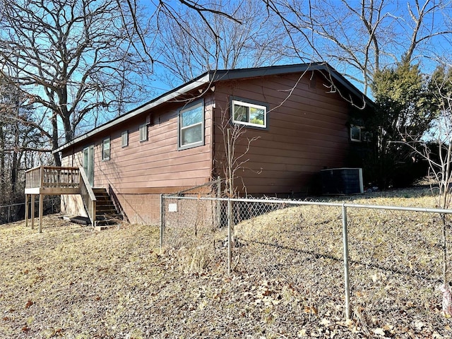 view of property exterior with central AC unit and a deck