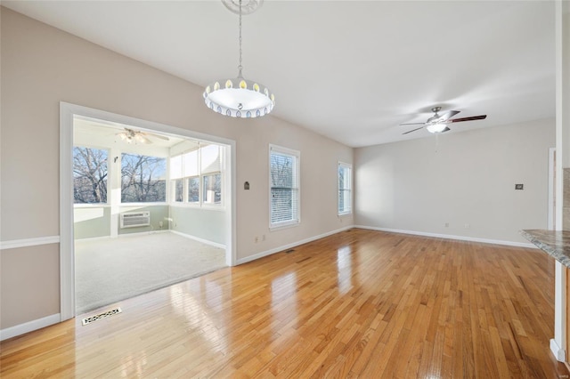 empty room with light wood-type flooring, visible vents, and ceiling fan