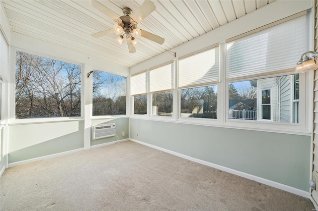 unfurnished sunroom with a healthy amount of sunlight, ceiling fan, and a wall unit AC