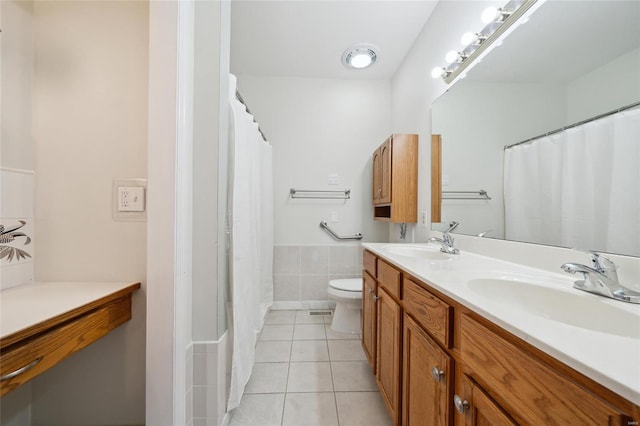 bathroom featuring tile patterned floors, toilet, double vanity, and a sink