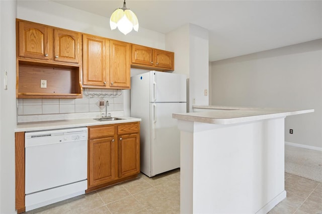 kitchen with decorative backsplash, white appliances, light countertops, and a sink