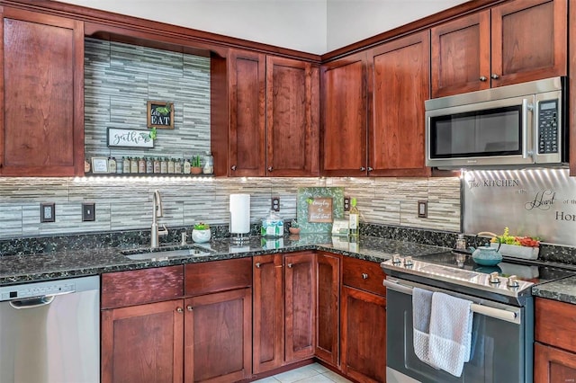 kitchen featuring stainless steel appliances, sink, dark stone countertops, and decorative backsplash