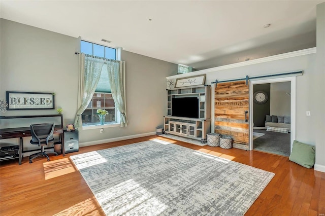 living room with a barn door and hardwood / wood-style floors