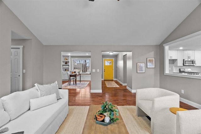 living room with vaulted ceiling, recessed lighting, baseboards, and wood finished floors