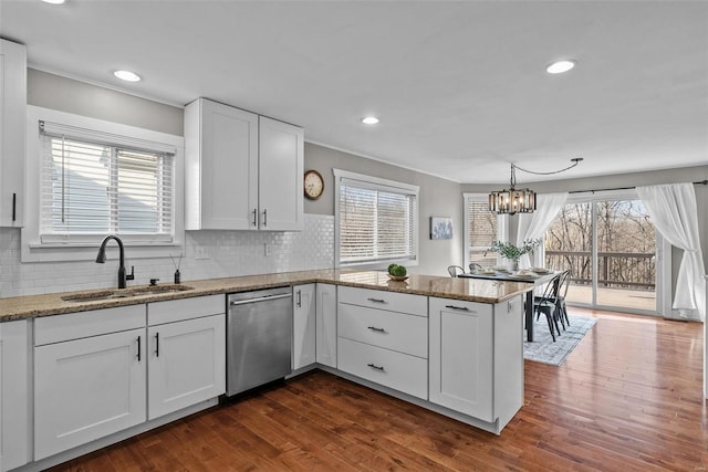 kitchen with a sink, dark wood finished floors, white cabinetry, a peninsula, and dishwasher