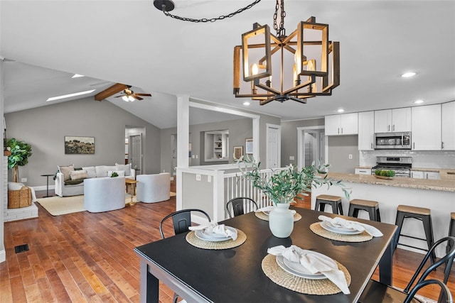 dining room with lofted ceiling with beams, light wood-style flooring, recessed lighting, and ceiling fan with notable chandelier