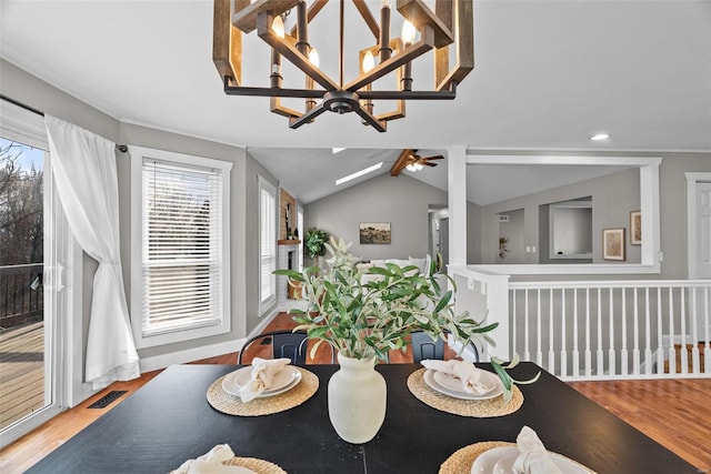 dining space with visible vents, wood finished floors, baseboards, lofted ceiling, and ceiling fan