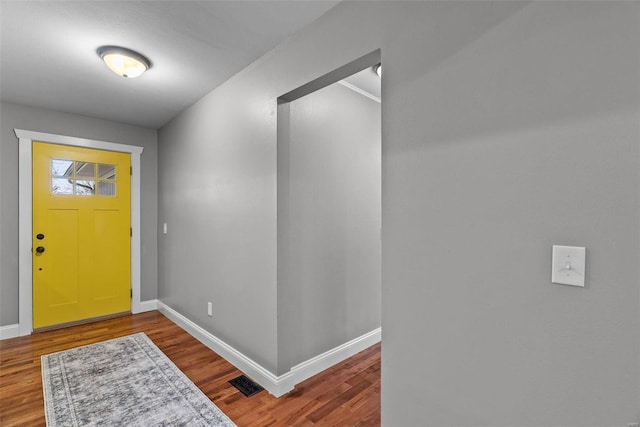 foyer entrance featuring visible vents, wood finished floors, and baseboards