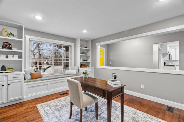 office space with visible vents, light wood-style flooring, built in features, recessed lighting, and baseboards