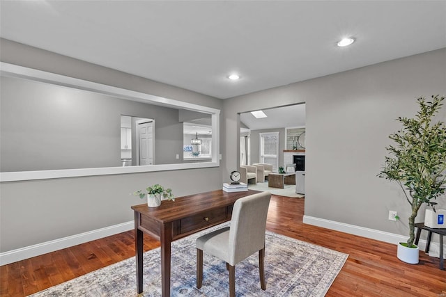 home office with a fireplace, recessed lighting, wood finished floors, and baseboards