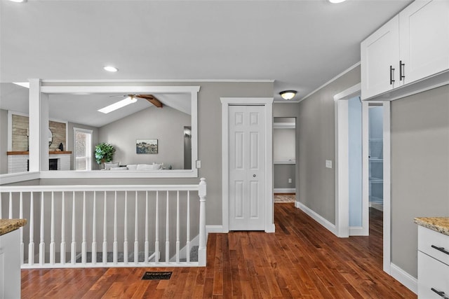 corridor with visible vents, crown molding, baseboards, and wood finished floors